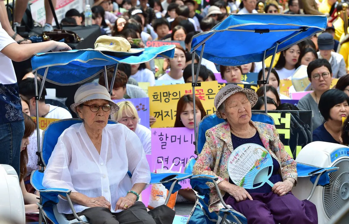 South Korean former "comfort women" Kim Bok-Dong (L) and Gil Won-Ok (R), who were forced to serve as sex slaves for Japanese troops during World War II, attend a protest with other supporters to demand Tokyo's apology for forcing women into military brothels during the war outside the Japanese embassy in Seoul on Aug. 12, 2015. (Jung Yeon-Je/AFP/Getty Images)