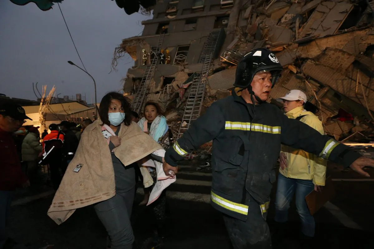 Rescue personnel and survivors at the site of a collapsed building in the southern Taiwanese city of Tainan following a strong 6.4-magnitude earthquake that struck the island early on February 6, 2016. (JOHNSON LIU/AFP/Getty Images)