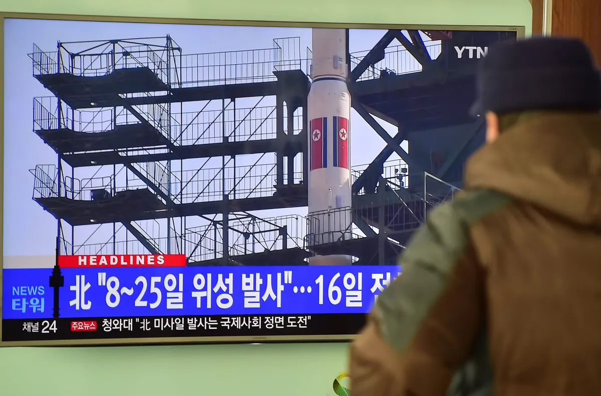 A man watches a news report on North Korea's planned rocket launch as the television screen shows file footage of North Korea's Unha-3 rocket which launched in 2012, at a railway station in Seoul on Feb. 3, 2016. (Jung Yeon-je/AFP/Getty Images)