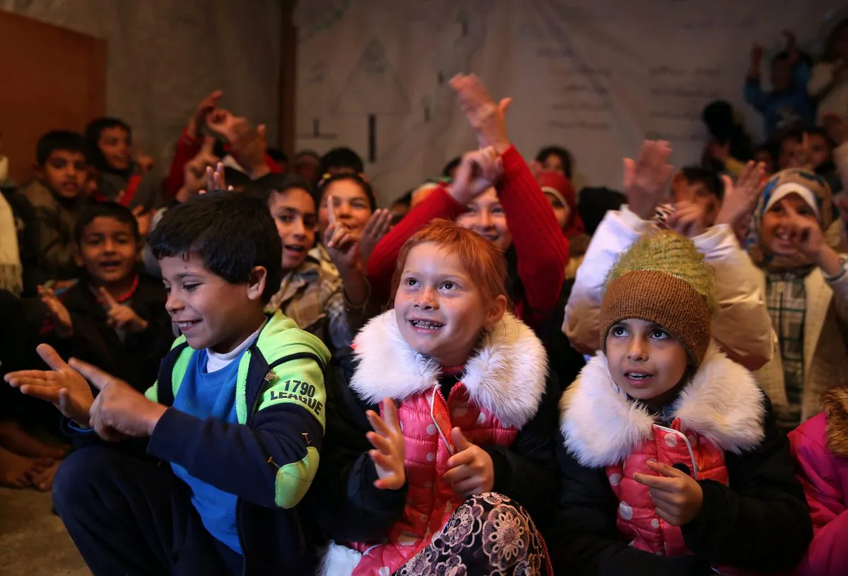 Syrian refugee children respond to their teacher inside a tent that has been turned into a makeshift school at a refugee camp in Lebanon, Jan. 27, 2016. Foreign Affairs Minister Stephane Dion says Lebanon and Jordan need more Canadian help in order to survive the pressure of the Syrian civil war. (AP Photo/Bilal Hussein)
