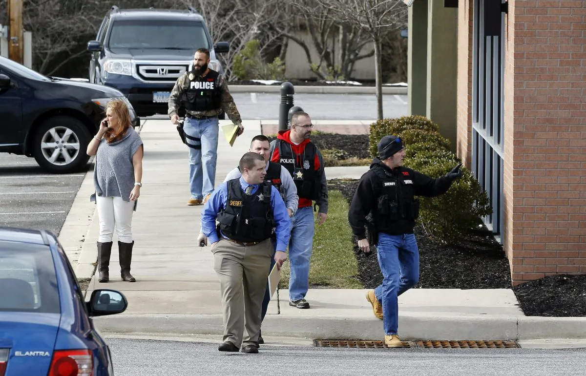 Investigators walk at the scene of a shooting at a shopping center in Abingdon, Md., Wednesday, Feb. 10, 2016. A man opened fire inside a shopping center restaurant during lunchtime. (AP Photo/Patrick Semansky)