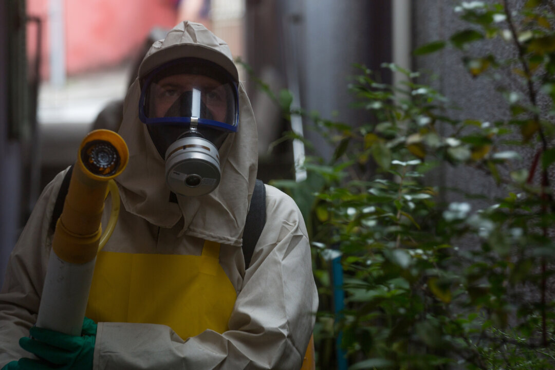 Agents working in pesticide fogging to combat the larvae of Aedes aegypti, the mosquito transmitor of the Zika virus, in the Butanta neighborhood in Sao Paulo, Brazil, on Jan. 29, 2016. (Victor Moriyama/Getty Images)