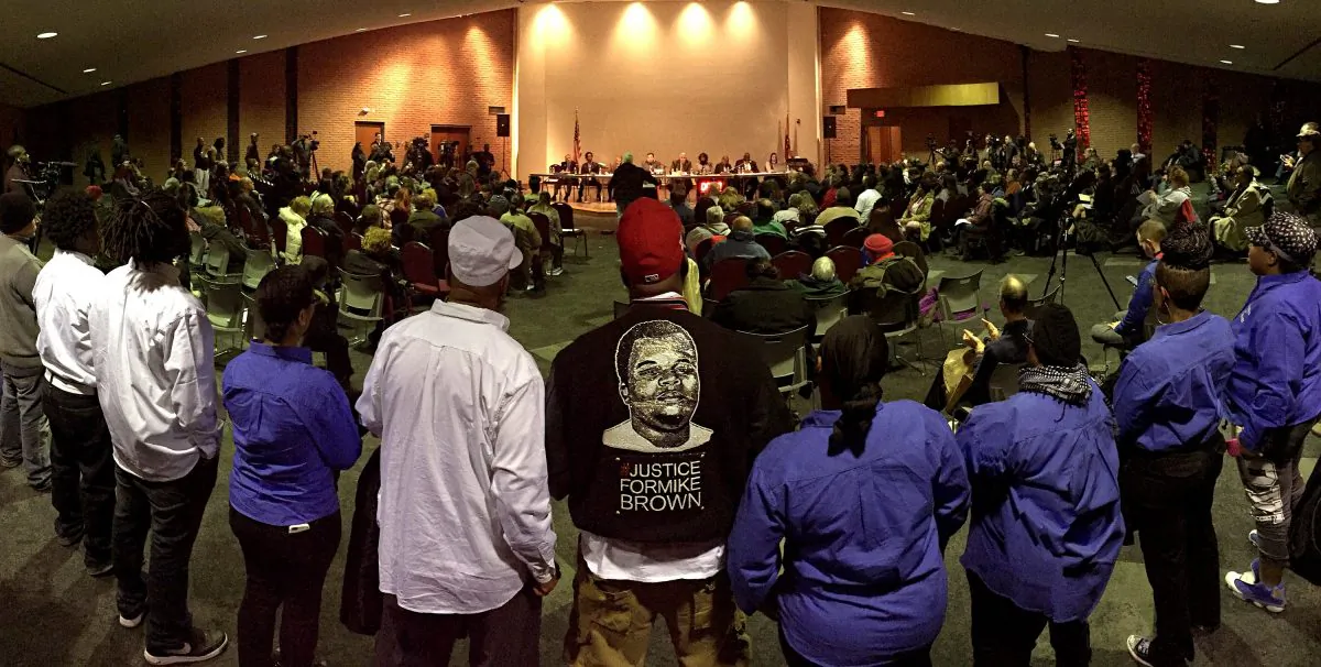 Mike Brown Sr., center, listens to part of the public comment portion of the Ferguson city council meeting in Ferguson on Tuesday, Feb. 9, 2016, where the consent decree with the United States Department of Justice was being talked about. The Ferguson city council voted to approve a modified version of the consent decree. This picture was shot as a panorama on an iPhone. (David Carson/St. Louis Post-Dispatch via AP)
