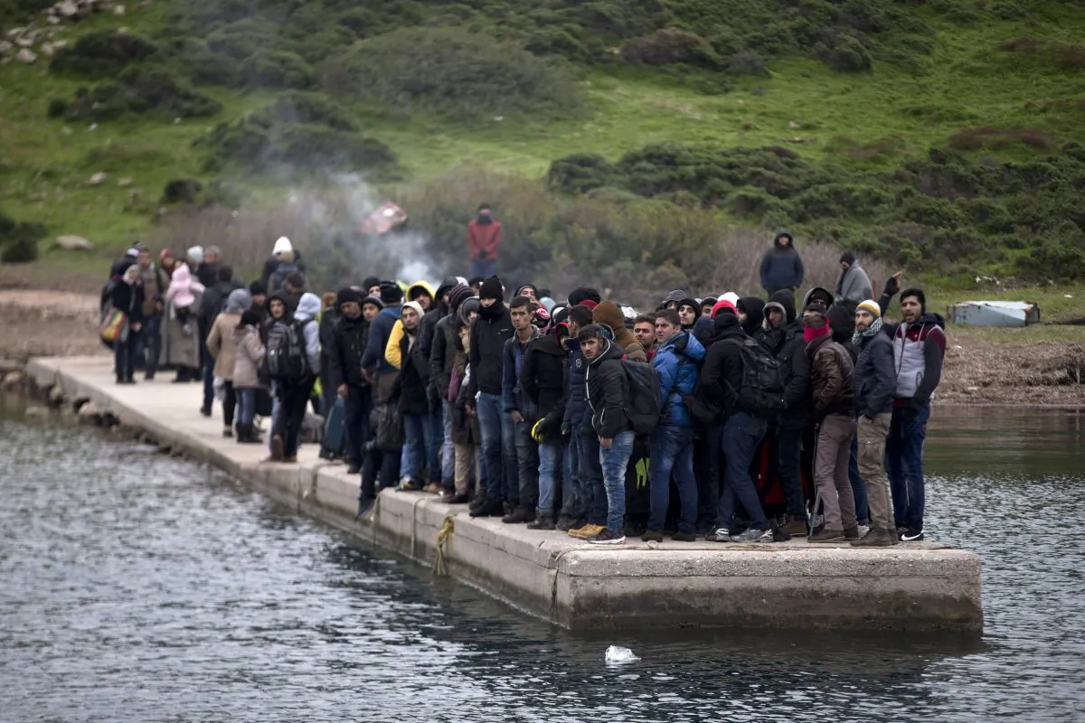 Migrants who have arrived at the shore of the deserted Greek island of Pasas wait for the coast guard to transport them to the islands of Oinousses on Jan. 20, 2016. (Petros Giannakouris/AP Photo)