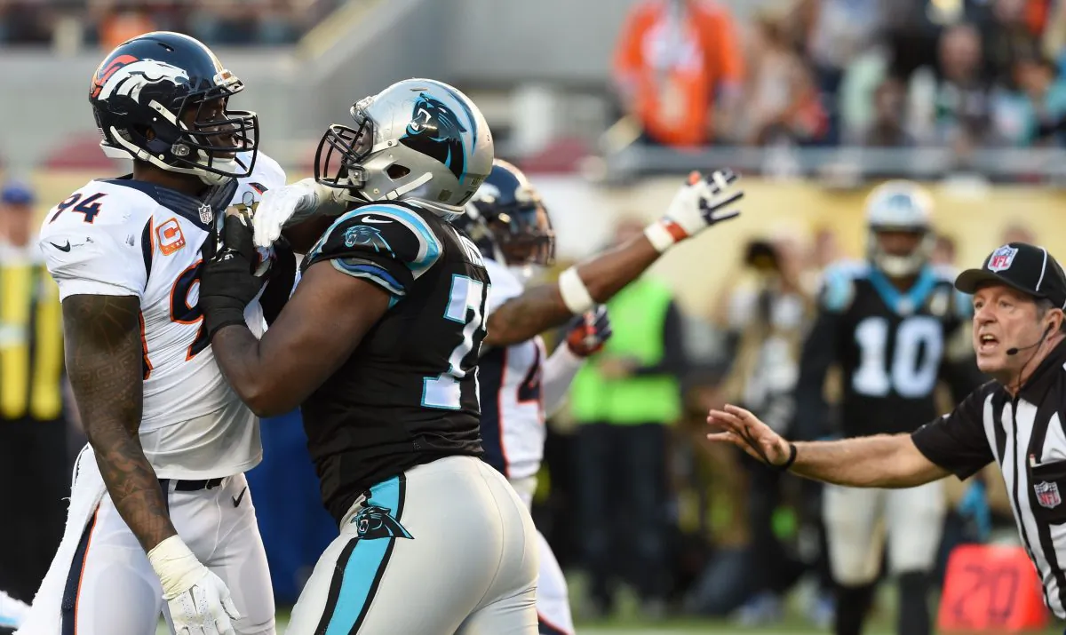 Michael Oher (C) of the Carolina Panthers struggled blocking DeMarcus Ware (L) at times during Super Bowl 50 as he sometimes had trouble with the field. (Timothy A. Clary/AFP/Getty Images)