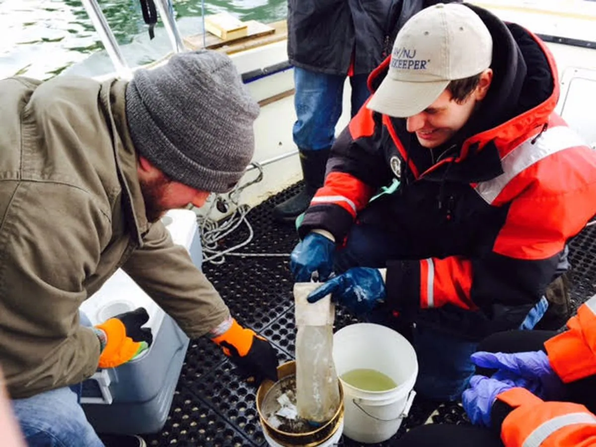 In this March 31, 2015 photo provided by NY/NJ Baykeeper, Mitchell Mickley left, and Justin Procopio process samples of water just collected from New York Harbor near the Statue of Liberty. A report by NY/NJ Baykeeper, says the waterways surrounding New York City are a soup of plastic, ranging from discarded takeout containers down to tiny beads that end up in the food supply. (Sandra Meola/NY/NJ Baykeeper via AP)