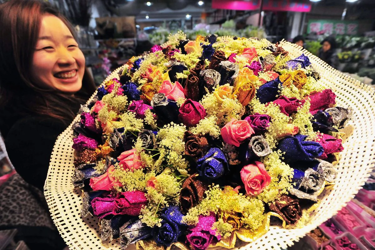 A woman poses with a bouquet of roses at a flower market in China as Valentine’s Day approaches in this file photo. (ChinaFotoPress/Getty Images)