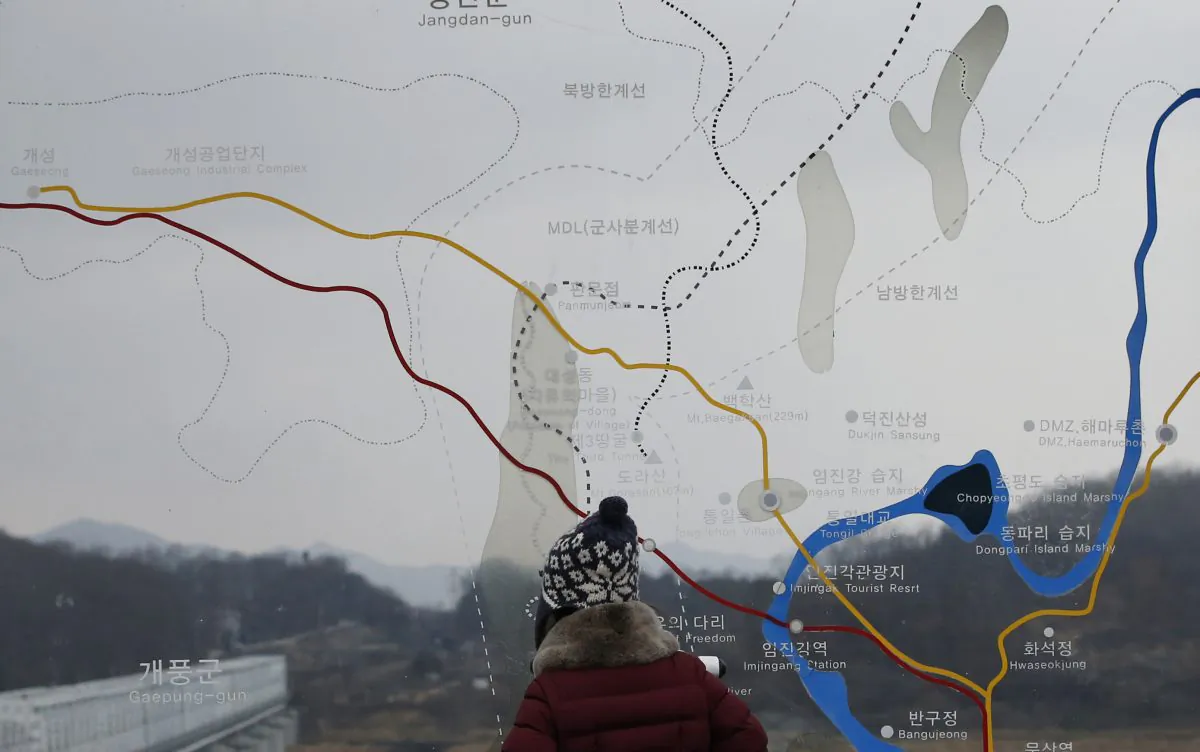 A visitor watches the North side through the glass showing a map of the Kaesong iIndustrial Complex and the border area between North and South Koreas at the Imjingak Pavilion near the border village of Panmunjom, which has separated the two Koreas since the Korean War, in Paju, South Korea, on Feb. 14, 2016. (AP Photo/Lee Jin-man)