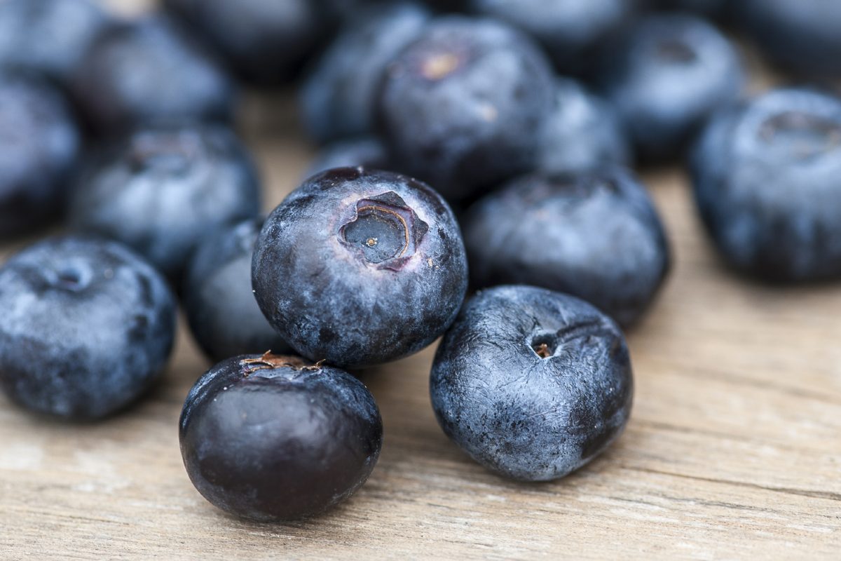 Blueberries on wooden table; focus on single blueberry (Shallow DOF)
