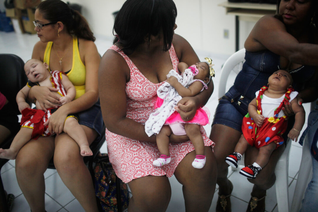 Babies born with microcephaly, are held by their mothers at a Carnival party held for babies with the condition in a health clinic on February 4, 2016 in Recife, Pernambuco state, Brazil. (Mario Tama/Getty Images)