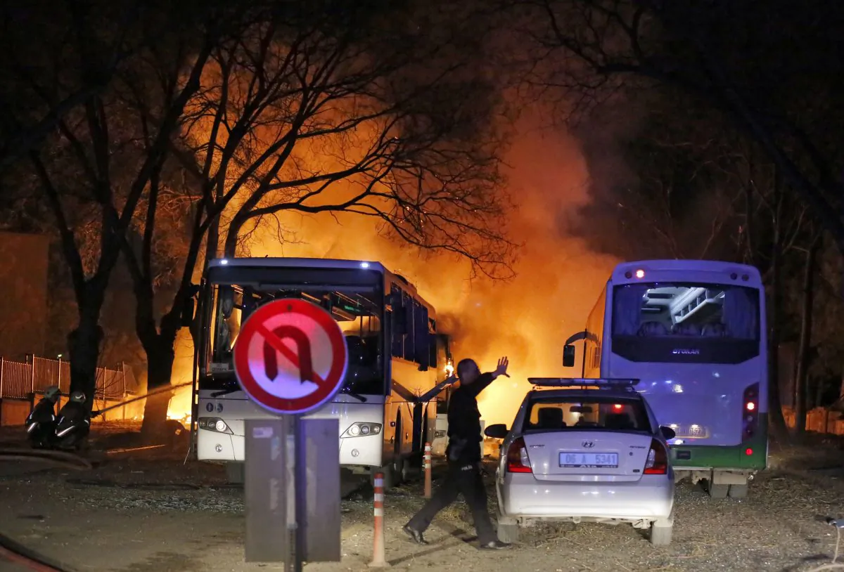 A police officer clears the area of an explosion in Ankara on Feb. 17, 2016, after assailants exploded a car bomb near vehicles carrying military personnel in the Turkish capital, killing several people and injuring scores of others. (Mustafa Kirazli/Cihan News Agency via AP)