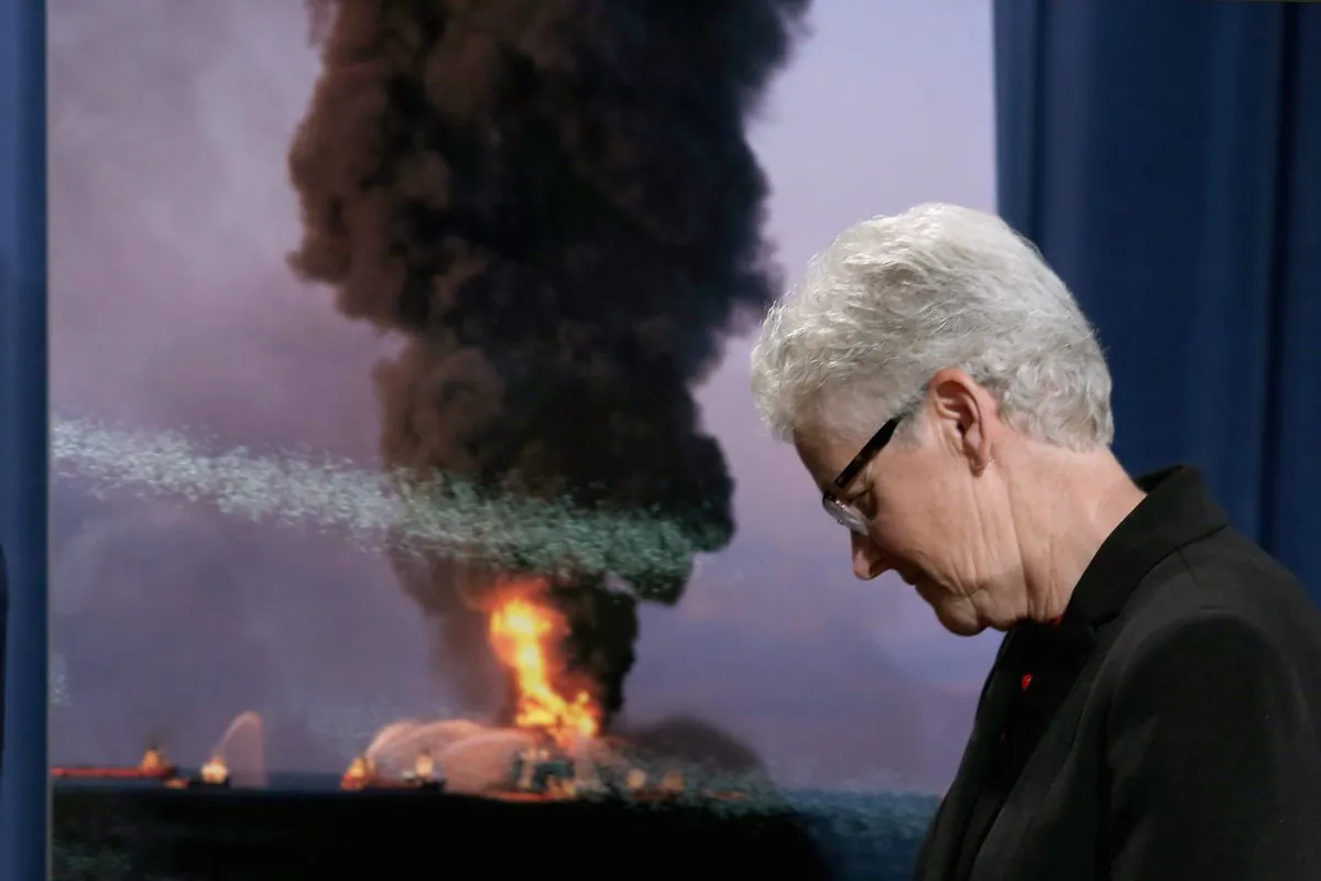 U.S. Environmental Protection Agency Director Gina McCarthy walks past a photograph of the April 2010 Deepwarter Horizon platform in flames after announcing the resolution of federal and state claims against BP at the Robert F. Kennedy building October 5, 2015 in Washington, DC. (Chip Somodevilla/Getty Images)