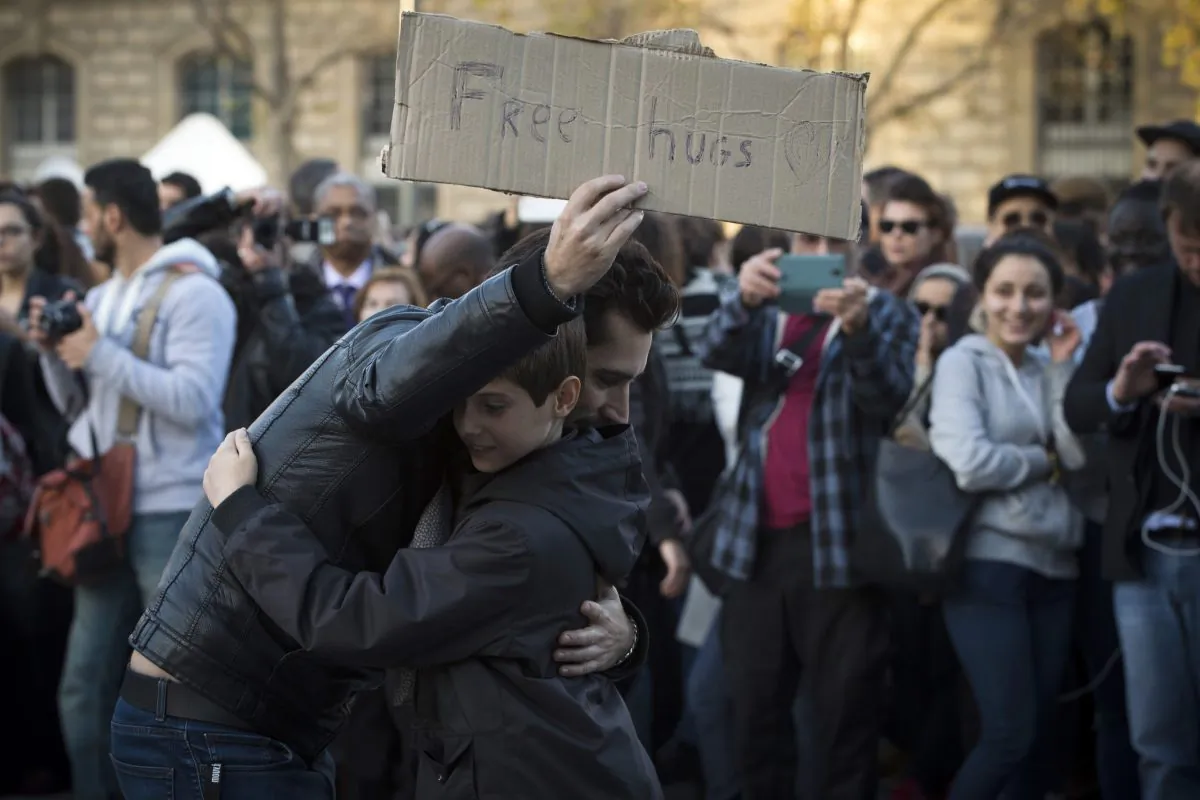 A man offers free hugs at the Place de la Republique in Paris, on Nov. 15, 2015. (JOEL SAGET/AFP/Getty Images)