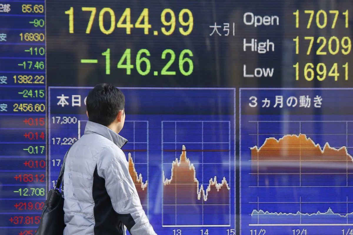 A man look at an electronic stock indicator of a securities firm in Tokyo on Feb. 4, 2016. (AP Photo/Shizuo Kambayashi)
