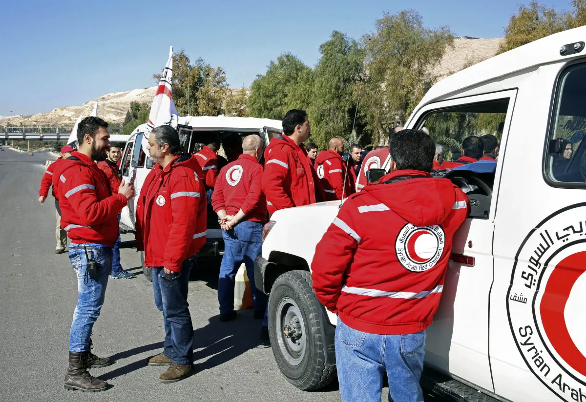 Staff from the Syrian Arab Red Crescent get ready to accompany a convoy of humanitarian aid as it waits in front of the United Nations Relief and Works Agency (UNRWA) offices before making their way into the government besieged rebel-held towns of Madaya, al-Zabadani and al-Moadhamiya in the Damascus countryside, as part of a U.N.-sponsored aid operation, in Damascus, Syria, Wednesday,  Feb. 17,  2016.  (AP Photo)