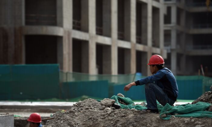 A construction worker rests near a building in the new Yujiapu financial district in Tianjin, northern China, on May 14, 2015. (Greg Baker/AFP/Getty Images)