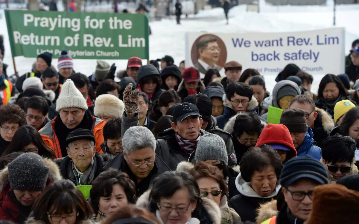 Members of Rev. Lim's congregation pray on Parliament Hill in Ottawa on Wednesday, Feb. 17, 2016, as they call for the release of Canadian Reverend Hyeon Soo Lim from his imprisonment in North Korea. (The Canadian Press/Sean Kilpatrick)