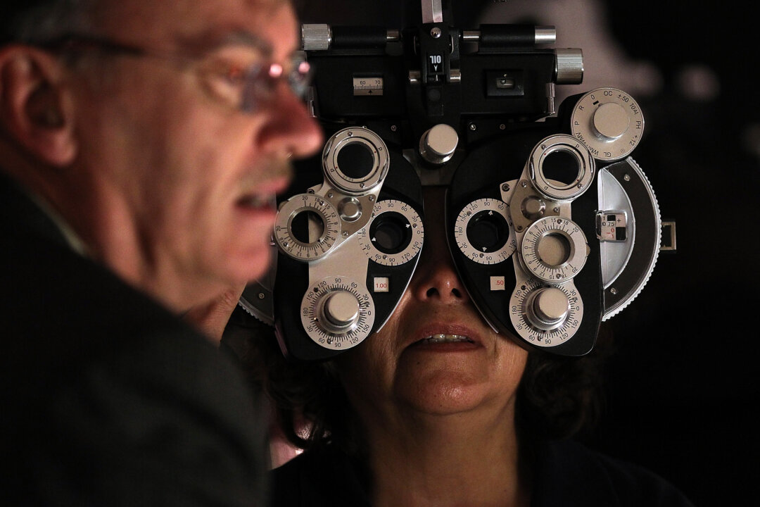 A volunteer optometrist performs a free eye exam during the Remote Area Medical (RAM) free clinic at the O.co Coliseum in Oakland, Calif., on March 22, 2012. (Justin Sullivan/Getty Images)