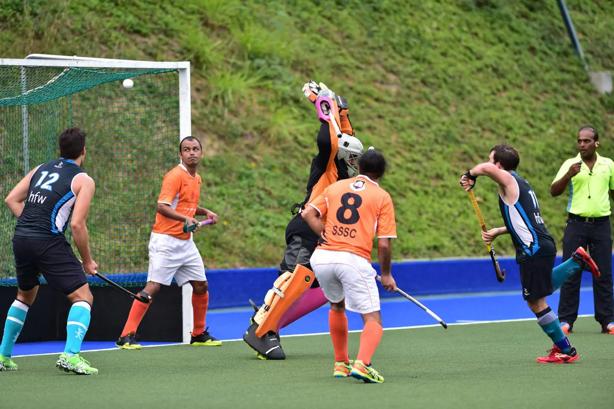 Angus Allan (Blue No 11) scores for HK Football Club against SSSC in the HKHA Premier Division match at King's Park on Sunday Feb 14, 2016. (Bill Cox/Epoch Times)