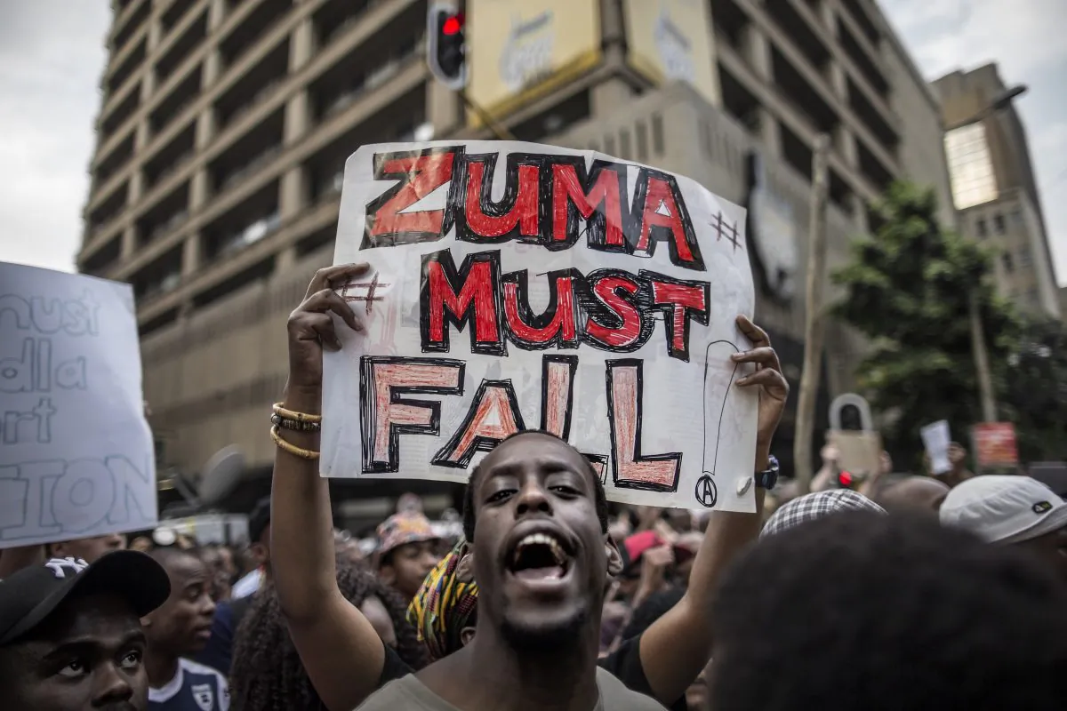 A student holds a placard reading "Zuma must fall" outside the Luthuli House, the African National Congress (ANC) party headquarters, on Oct. 22, 2015, in Johannesburg, during a demonstration of thousands of students against university fee hikes, government corruption, and economic turmoil. (Marco Longari/AFP/Getty Images)