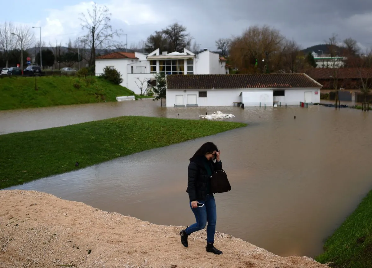 A woman walks on an improvised dike in a flooded area in Coimbra, central Portugal, on February 14, 2016. (FRANCISCO LEONG/AFP/Getty Images)