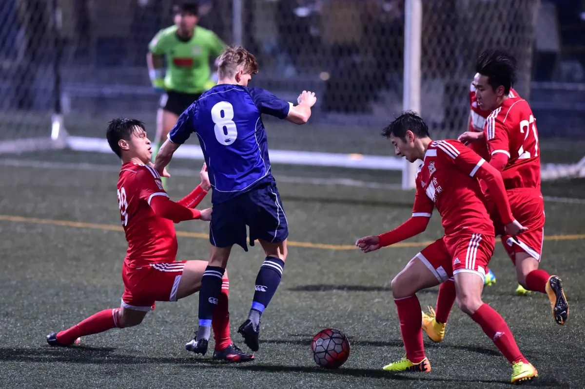 Frederick Schipper is stopped by the Wanchai defence during their 1-nil victory in the HKFA first division match at Sports Road on Saturday Feb 20, 2016. (Bill Cox/Epoch Times)