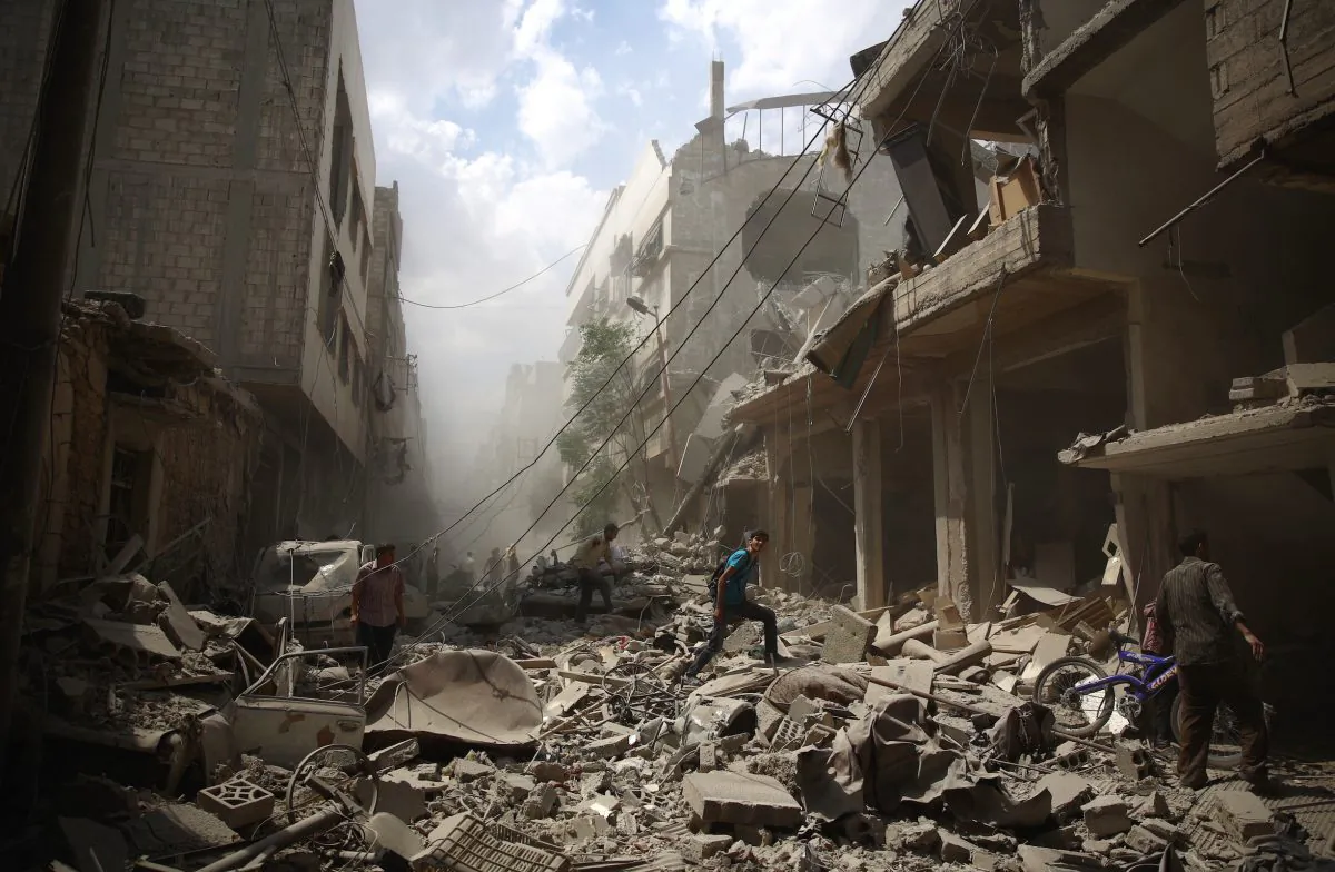 Syrians walk amid the rubble of destroyed buildings following reported airstrikes by regime forces in Douma, east of the capital Damascus, on Aug. 30, 2015. More than 260,000 people have been killed since Syria's conflict began in March 2011, and millions have been displaced by the war. (Abd Doumany/AFP/Getty Images)