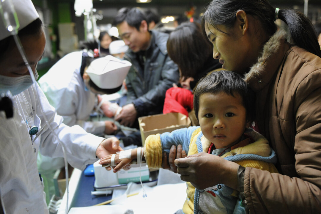 A group of Chinese children accompanied by their parents get treatment for flu at a hospital in Hefei, east China's Anhui Province, on Jan. 8, 2010.(STR/AFP/Getty Images)