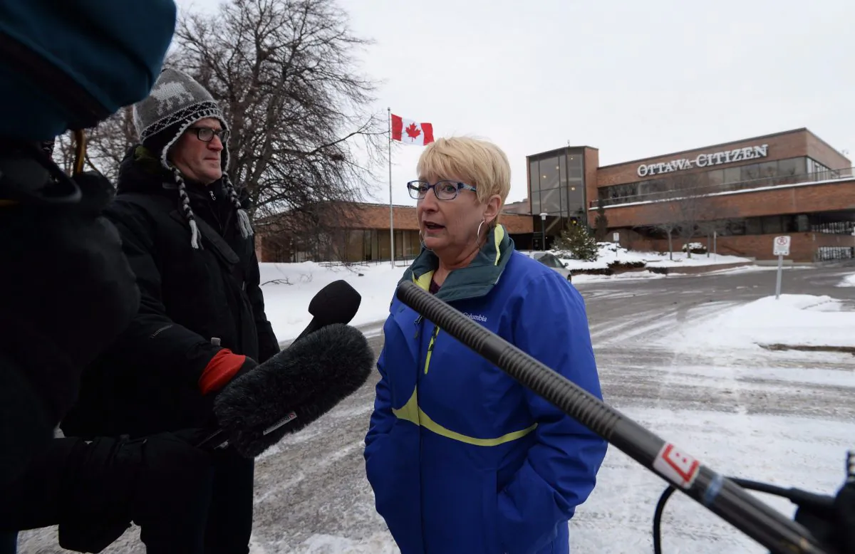 Debbie Cole, president of the Ottawa Newspaper Guild, speaks to reporters outside the offices of the Ottawa Citizen and Ottawa Sun on Jan 19 after Postmedia announced it was cutting approximately 90 jobs and merging newsrooms in four cities in an effort to slash costs amid mounting revenue losses. (THE CANADIAN PRESS/Sean Kilpatrick)