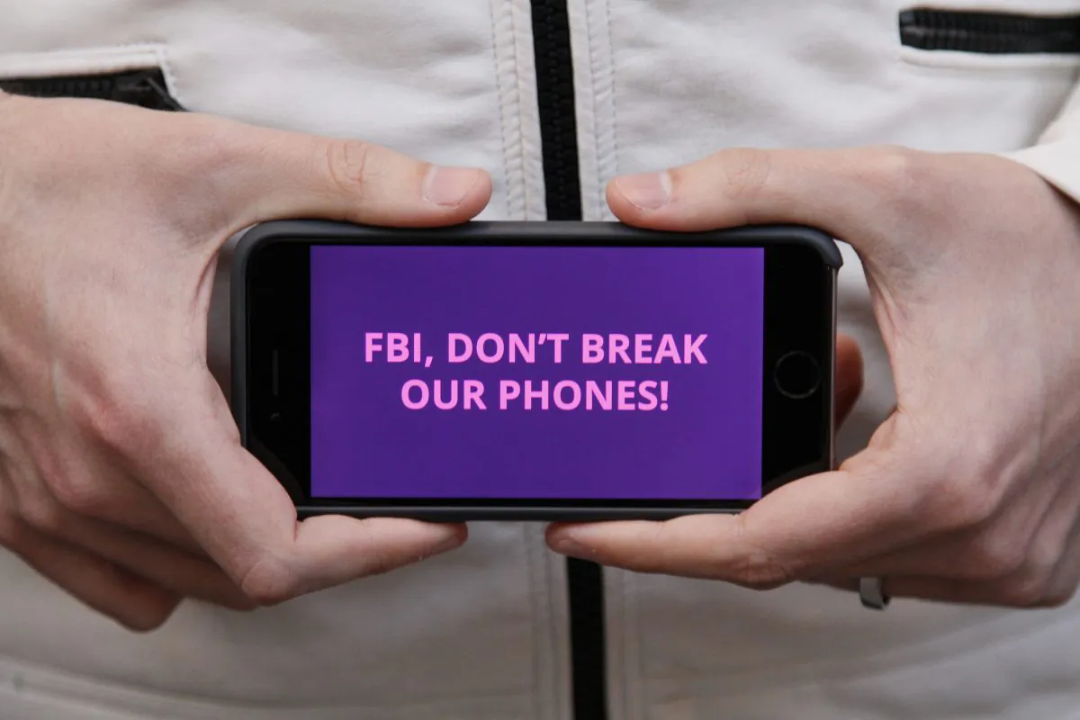 A man holds out his iPhone during a rally in support of data privacy outside the Apple store in San Francisco on Feb. 23, 2016. Protesters assembled in more than 30 cities to lash out at the FBI for obtaining a court order that requires Apple to make it easier to unlock an encrypted iPhone used by a gunman in December's mass murders in California. (AP Photo/Eric Risberg)