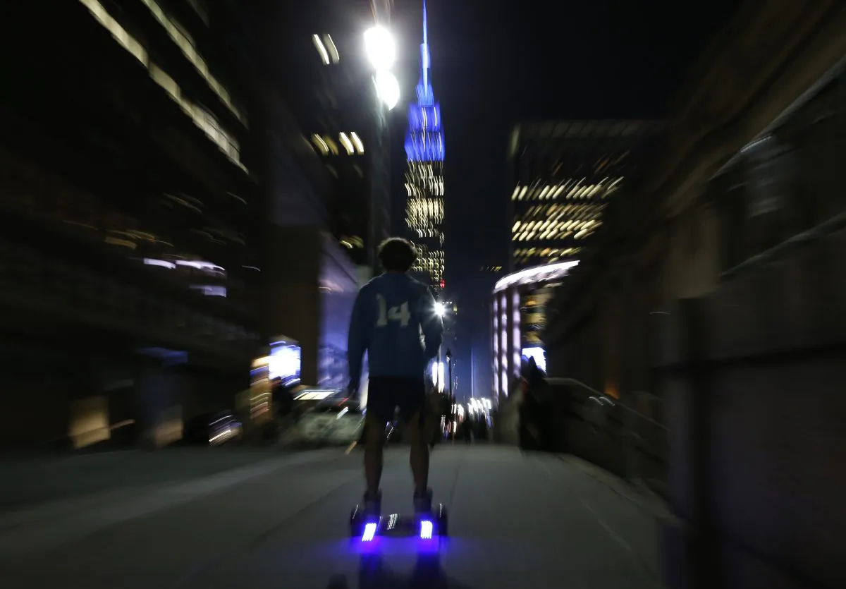 In this Oct. 21, 2015 file photo, a young man rides a hoverboard down a Manhattan street toward the Empire State Building in New York. (AP Photo/Kathy Willens)