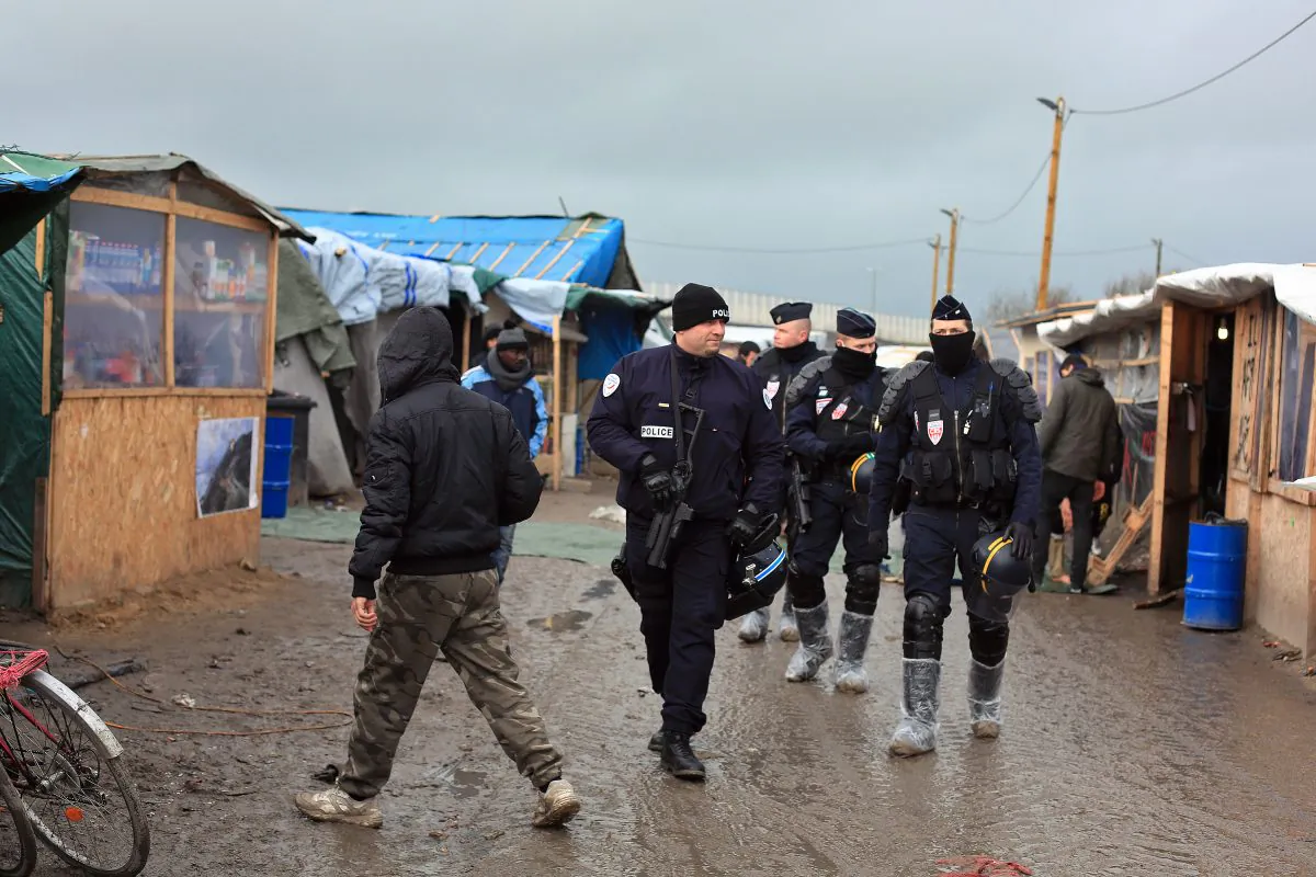French riot police officers patrol in the migrant camp in Calais, north of France, Friday, Feb. 5, 2016. (AP Photo/Thibault Camus)