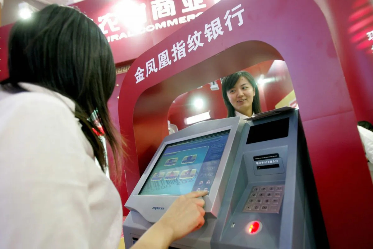 Chinese promoters show off the latest automated-teller machines at banking exhibition in Beijing 13 September 2007. (STR/AFP/Getty Images)