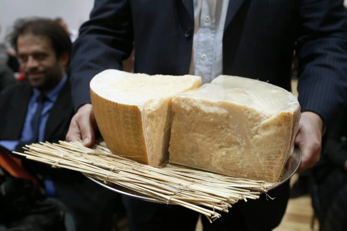 A man presents pieces of parmesan during a sale of fine food to raise funds for the French Red Cross on December 18, 2012 French auction house Artcurial in Paris. AFP PHOTO FRANCOIS GUILLOT (FRANCOIS GUILLOT/AFP/Getty Images)