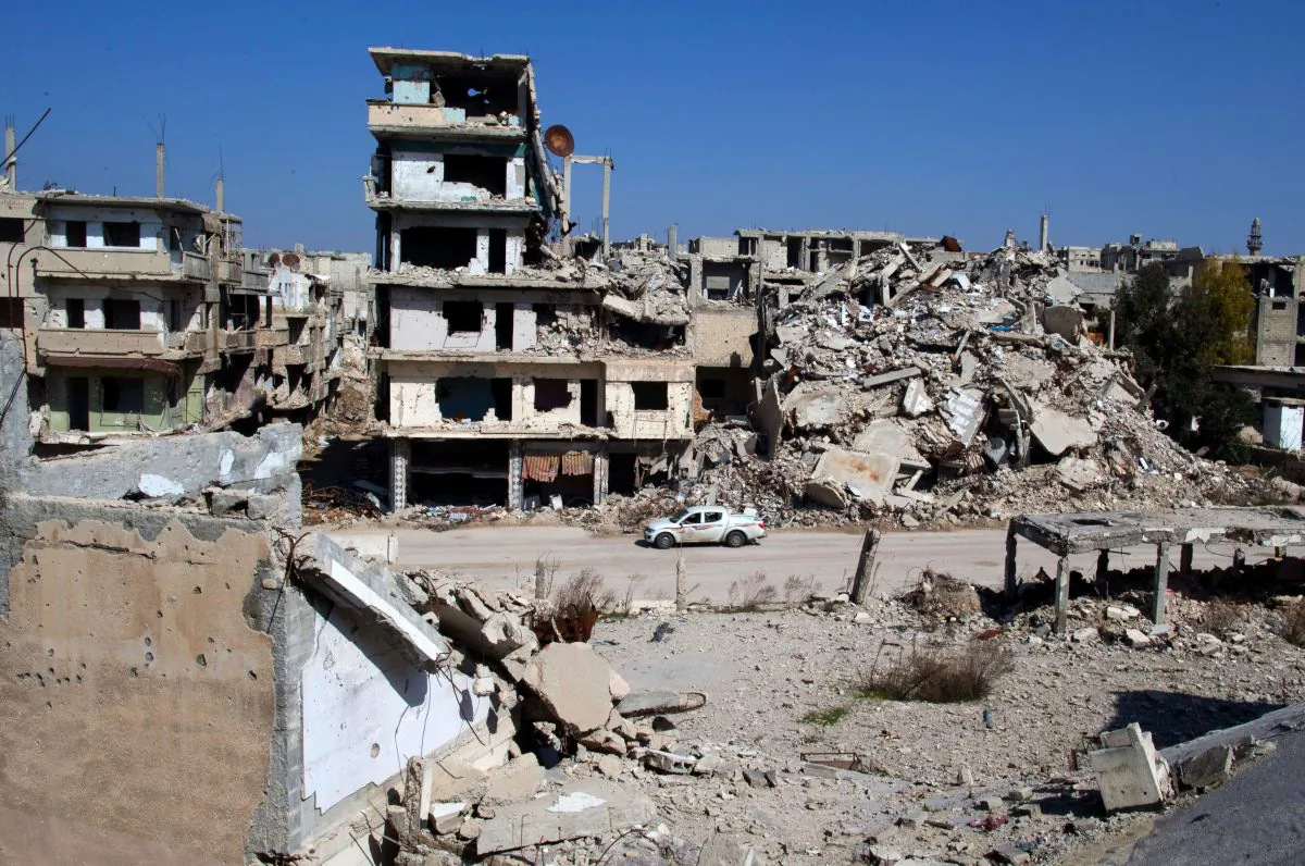 A car drives through a devastated part of the old city of Homs, Syria, on Feb. 26, 2016. Some 1,200 rebels and civilians, many of them wounded and starving from a yearlong siege, withdrew from the last remaining strongholds in the ancient heart of Homs in May 2014, surrendering to President Bashar Assad a bloodstained city once dubbed the “capital of the revolution.” (AP Photo/Hassan Ammar)