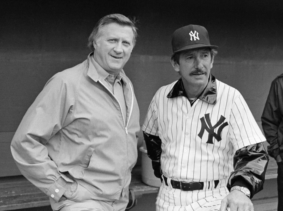 In this March 1, 1983, file photo, New York Yankees owner George Steinbrenner, left, and manager Billy Martin, get together outside the dugout at baseball spring training in Fort Lauderdale, Fla.  Steinbrenner owned the Yankees from 1973 until his death in July, and the team won seven World Series championships, 11 AL pennants and 16 AL East titles during his turbulent and blustery reign. Martin had five stints as Yankees manager under Steinbrenner, who fired him four times and let him resign once. (AP Photo/Ray Howard, File)