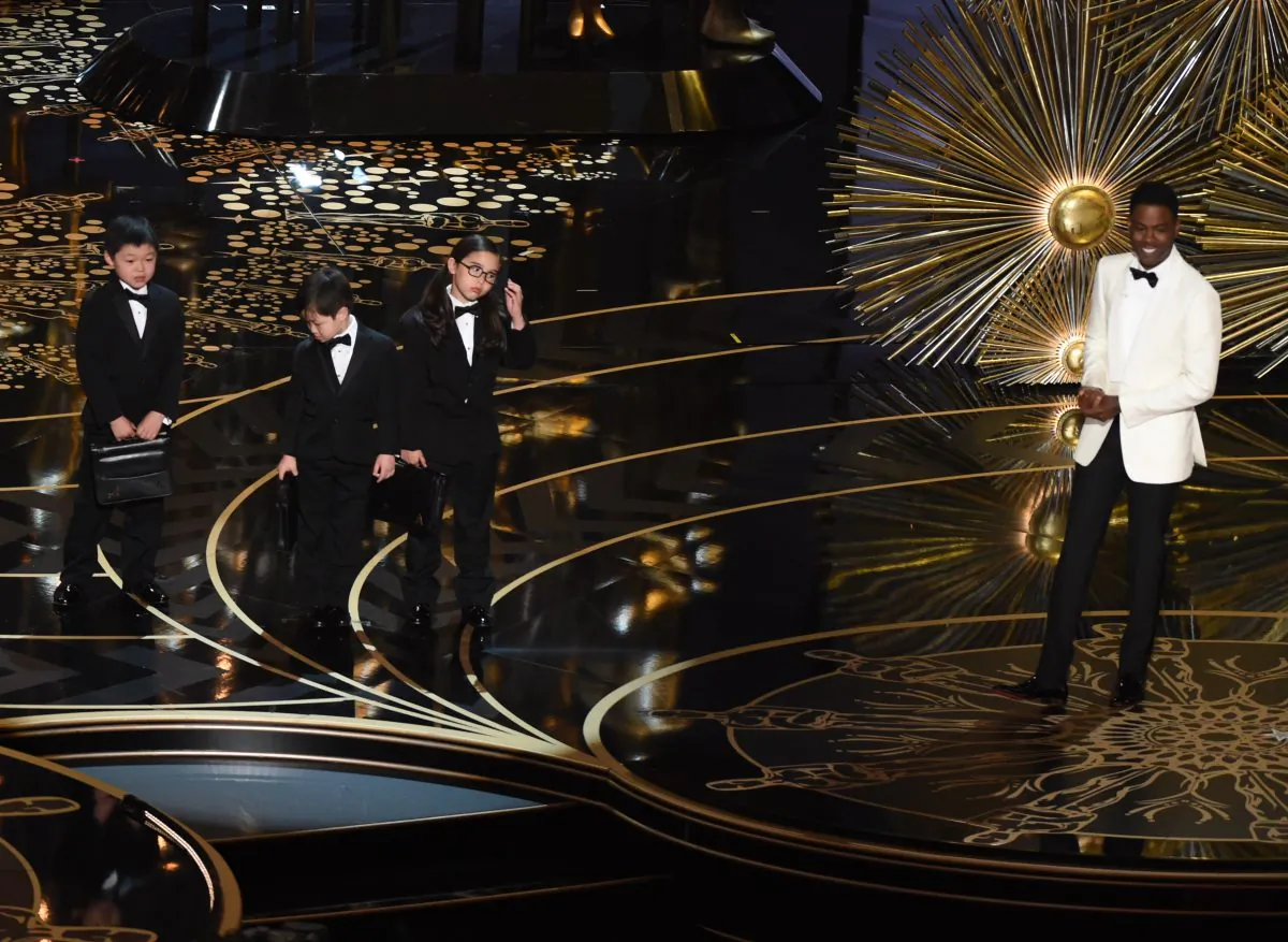 Actor Chris Rock presents children representing accountants from PricewaterhouseCoopers on stage at the 88th Oscars on Feb. 28, 2016 in Hollywood, California. (Mark Ralston/AFP/Getty Images) 