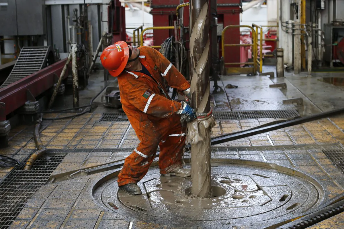 Oil worker Vicente Gonzalez looks up as the drill is pulled upwards on the Centenario deep-water drilling platform off the coast of Veracruz, Mexico, in the Gulf of Mexico, on Nov. 22, 2013. (AP Photo/Dario Lopez-Mills)