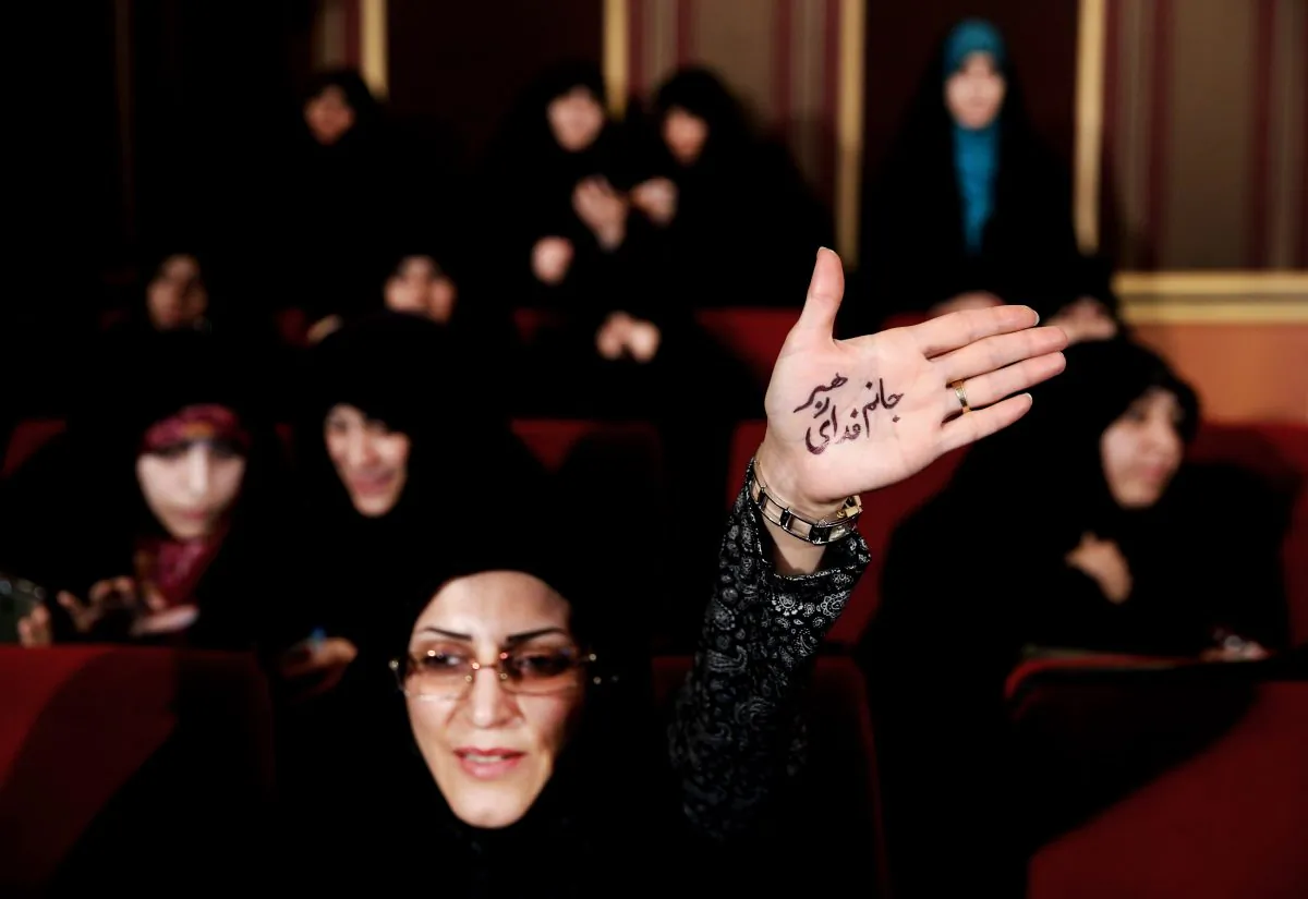 An Iranian hard-liner raises her palm with Persian that reads, "I'm ready to sacrifice myself for the Supreme Leader," during an anti-British campaign aimed at claiming reformist rivals of being backed by the BBC and the British government, in Tehran, Iran, on Feb. 24, 2016. Iranian moderates won a 59 percent majority in the Assembly of Experts, an 88-member body which will choose the successor to Ayatollah Ali Khamenei, who has been Iran's top decision-maker since 1989. The 76-year-old underwent prostate surgery in 2014, leading to renewed speculations about the state of his health. (AP Photo/Ebrahim Noroozi)