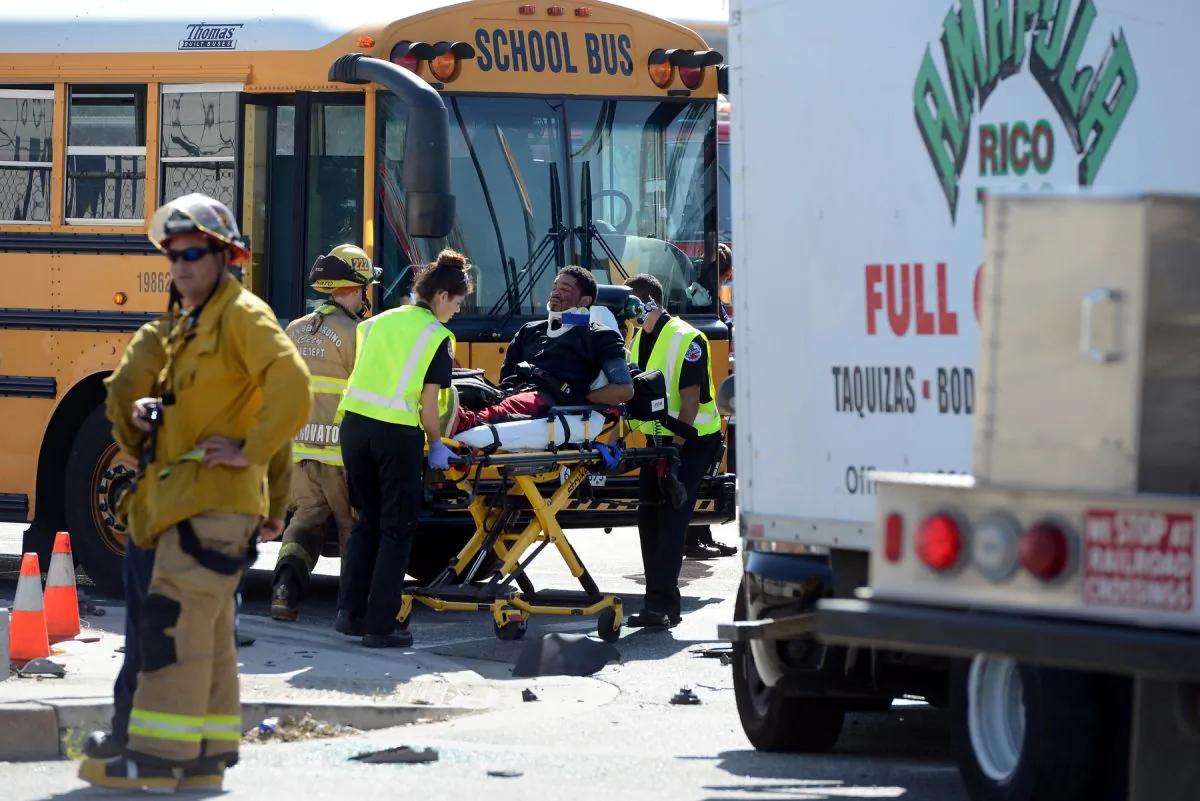 A man is transported to an ambulance at the scene of an accident involving a stolen taco truck and a school bus Monday, Feb. 29, 2016, in San Bernardino. Authorities in Southern California say two men fleeing from police in a stolen taco truck sideswiped a school bus full of children, took down the lights at an intersection and smashed into a propane truck. (Jennifer Cappuccio Maher/The Inland Valley Daily Bulletin via AP)  MANDATORY CREDIT
