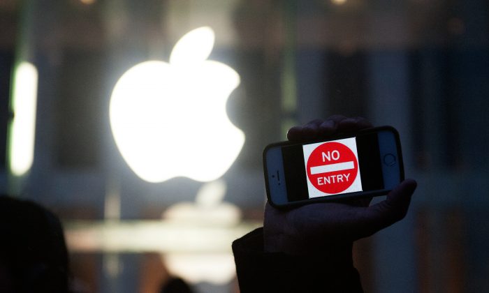 A protester holds up an iPhone that reads "No Entry" outside of the the Apple store on 5th Avenue in New York City on Feb. 23. While Apple claims to support user privacy in the United States, it has cooperated closely with authorities in China. (Bryan Thomas/Getty Images)