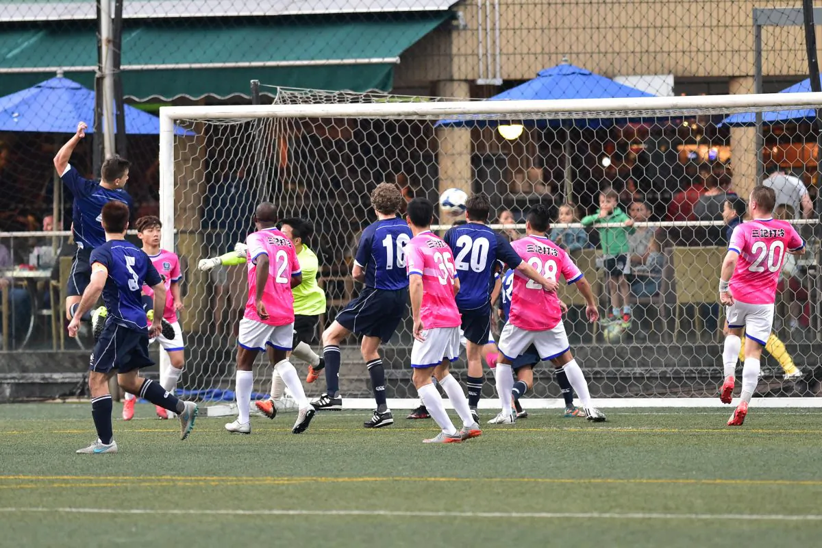 Lucky Mile (Blue) score with a fine angle header in their HKFA division 1 match at Sports Road on Sunday Feb 28, 2016, but Tai Chung were too good on the day, coming away with a 3-1 win. (Bill Cox/Epoch Times)