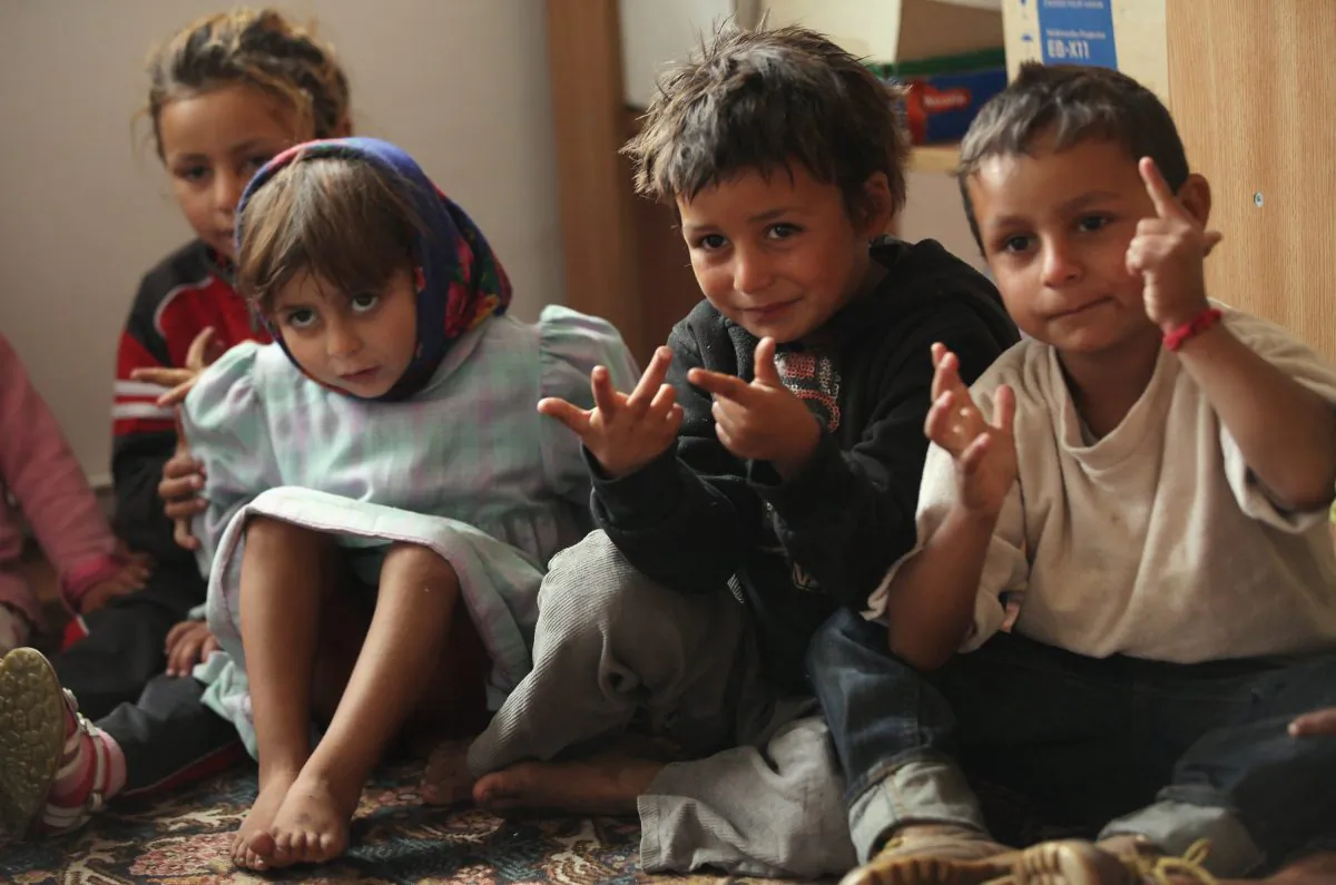 Young Roma children count with their fingers during a preschool class in the abjectly poor Roma settlement of Ponorata, Romania, on Sept. 10, 2013. A Romanian NGO called OvidiuRo, co-founded by Leslie Hawke, who is the mother of American actor Ethan Hawke, is attempting to get young Roma children to regularly attend pre-school through a coupon incentive system for food at Ponorata and 23 other Roma communities across Romania. Between 400 and 500 Roma live in squalor at Ponorata, few have access to electricity and 95% of them are illiterate and unemployed. Many Roma from Ponorata have spent time in France to earn money, mostly through begging and scrap metal collection. (Sean Gallup/Getty Images)