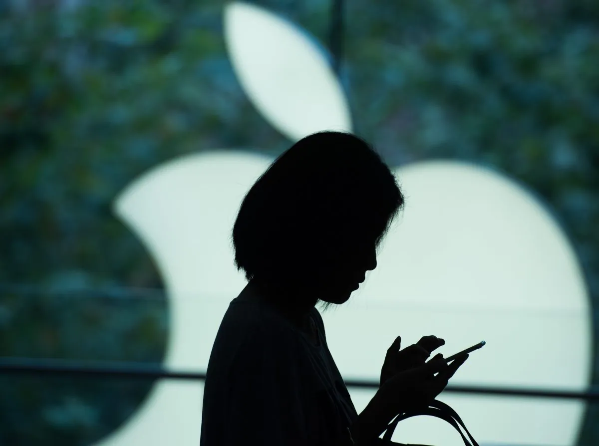 A woman uses her iPhone at an Apple store in Shanghai, China on Sept. 25, 2015. (Johannes Eisele/AFP/Getty Images)