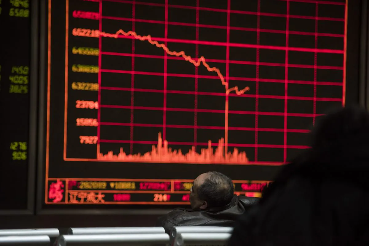 Investors watch stock prices on screens at a securities company in Beijing on Feb. 25, 2016. Chinese stocks and emerging market currencies are a sea of red for 2018 because of U.S. dollar liquidity tightening. (Fred Dufour/AFP/Getty Images)