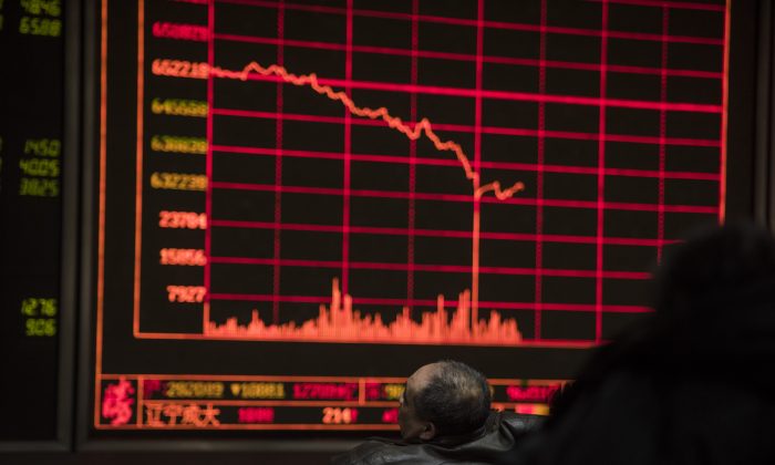Investors watch stock prices on screens at a securities company in Beijing on Feb. 25, 2016. Chinese stocks and emerging market currencies are a sea of red for 2018 because of U.S. dollar liquidity tightening. (Fred Dufour/AFP/Getty Images)