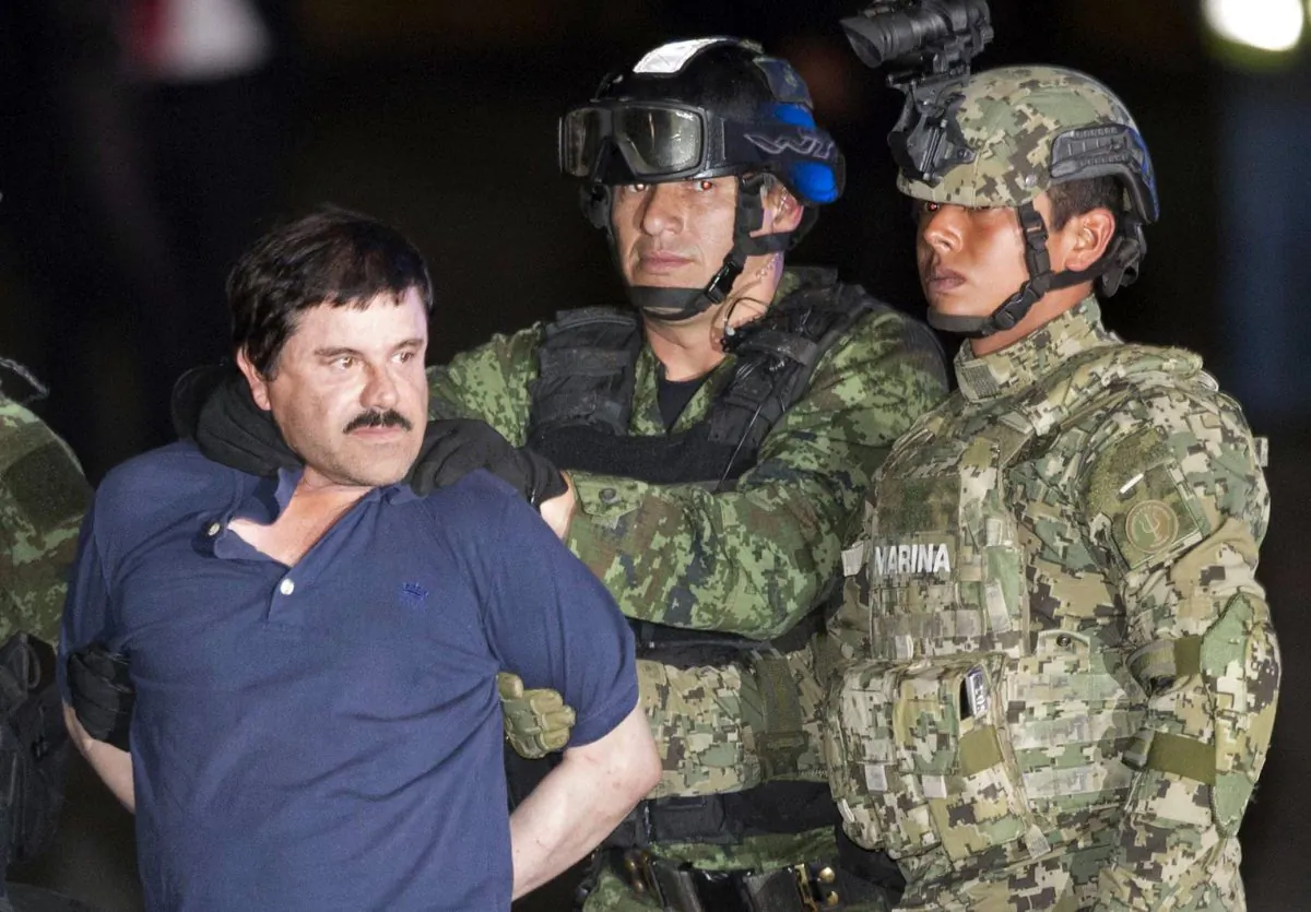 Joaquin "El Chapo" Guzman is made to face the press as he is escorted to a helicopter in handcuffs by Mexican soldiers and marines at a federal hangar in Mexico City, Mexico, on Jan. 8, 2016. (AP Photo/Eduardo Verdugo)