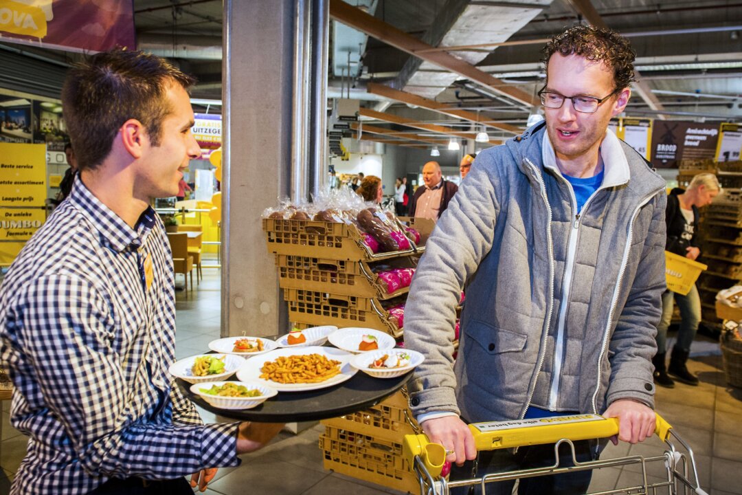 An employee offers samples of snacks made from insects to a customer in a store of Dutch supermarket chain Jumbo in Groningen (Remko de Waal/AFP/Getty Images)