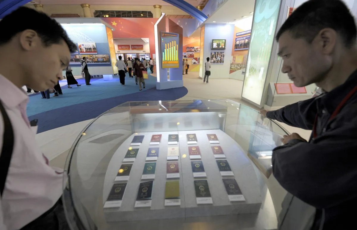 Two visitors look at Chinese passports from different periods in recent history in Beijing on Sept. 22, 2009. A Chinese professor in Sichuan Province recently said that colleges in the area were confiscating passports from academic staff. (Liu Jin/AFP/Getty Images)