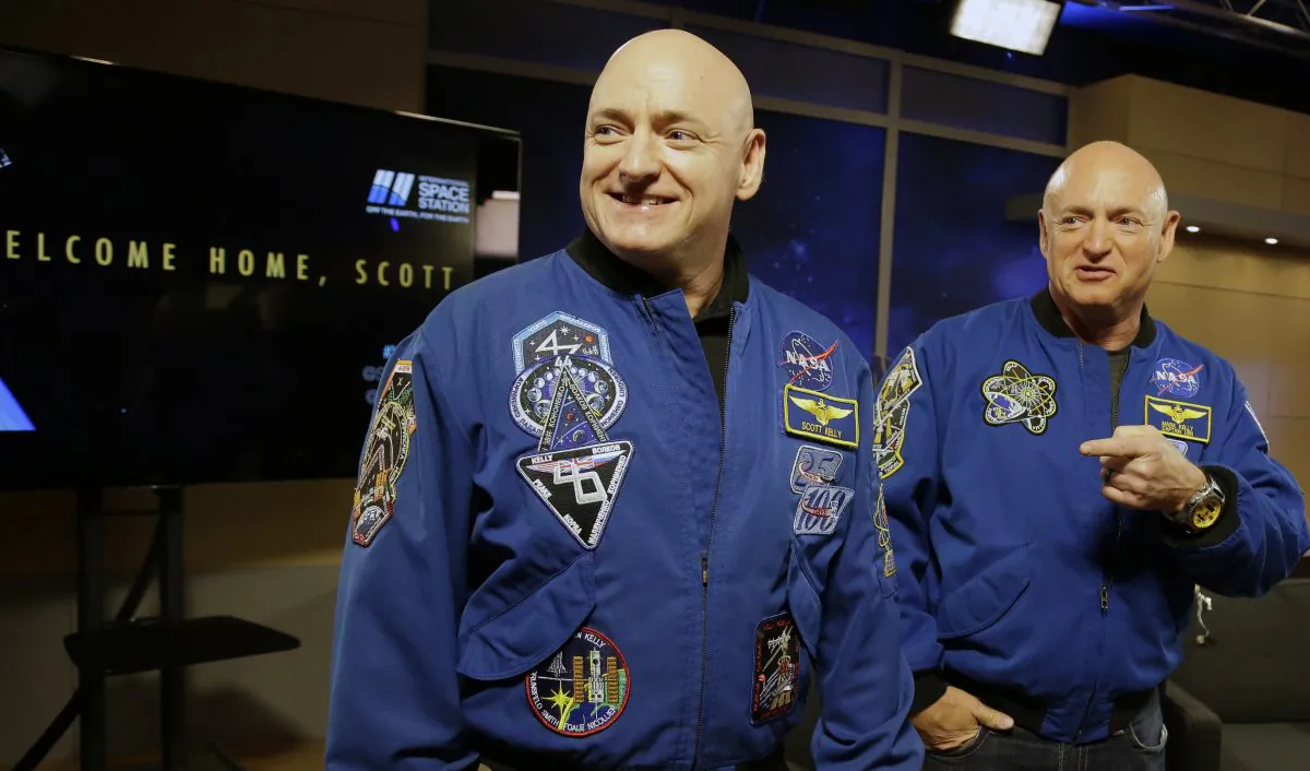 NASA astronaut Scott Kelly, left, and his twin Mark get together before a press conference Friday, March 4, 2016, in Houston. Scott Kelly set a U.S. record with his a 340-day mission to the International Space Station. (AP Photo/Pat Sullivan)